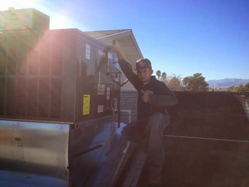 HVAC technician performing AC Tune-Up on a rooftop unit in Kernersville